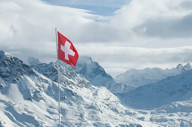 Focused on the Swiss flag in the background Engadine mountains, Switzerland