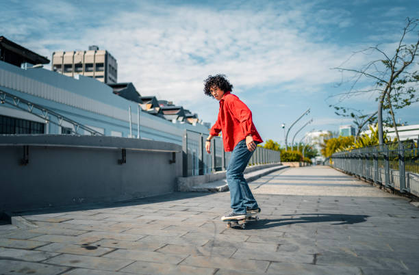 Asian Malay young man practicing skateboarding at pedestrian walkway during weekend morning