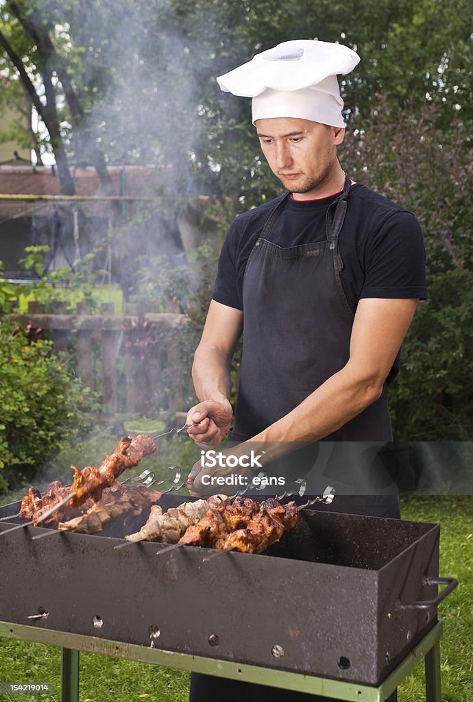Man cook Man cooking on brazier outdoors 20-29 Years Stock Photo