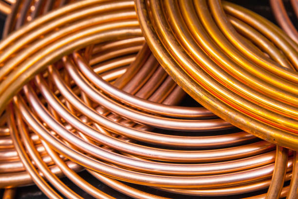 istock Twisted new copper tubes on a black background. 1542249016