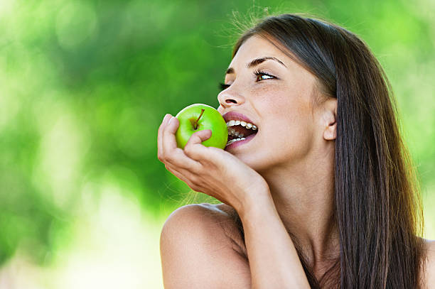 istock portrait young charming woman biting apple 154224906