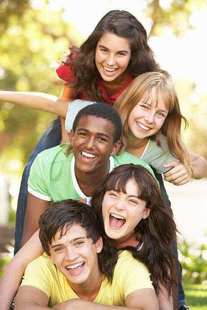 Group Of Teenagers Piled Up In Park Group Of Teenagers Having fun Piled Up In Park teenagers only stock pictures, royalty-free photos & images