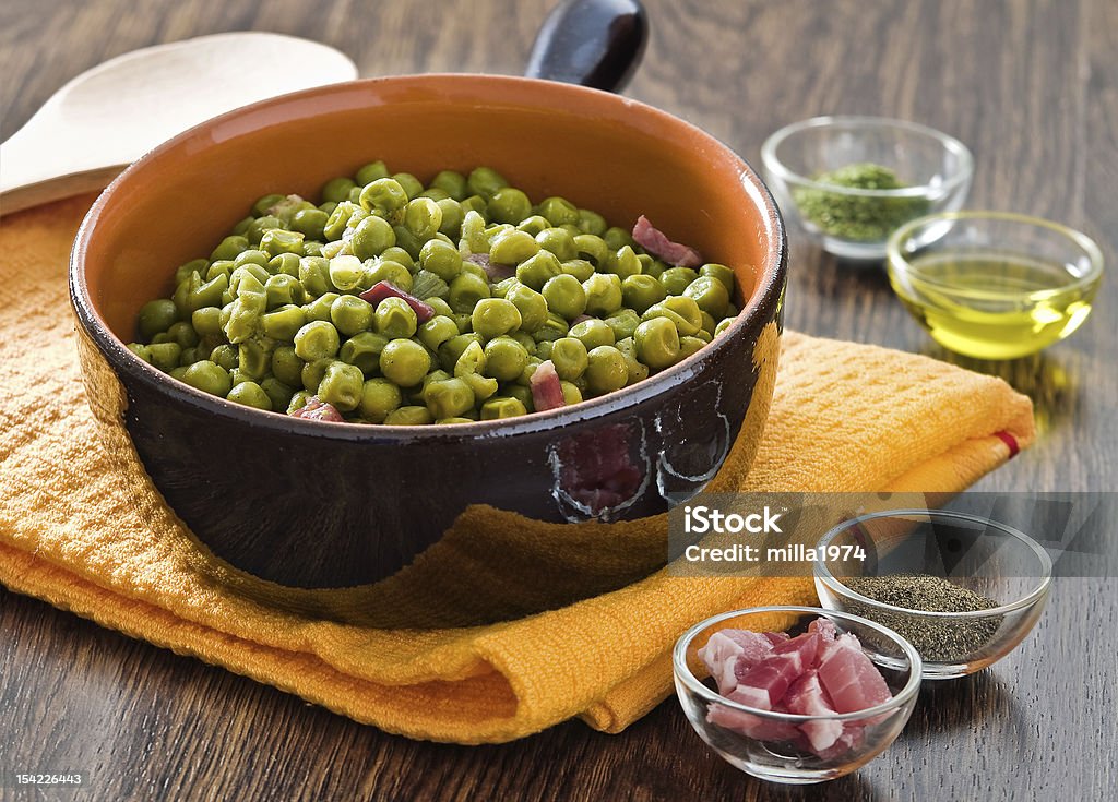 Peas with bacon in terracotta bowl. Peas with bacon in terracotta bowl with spices in glass bowl. Bacon Stock Photo