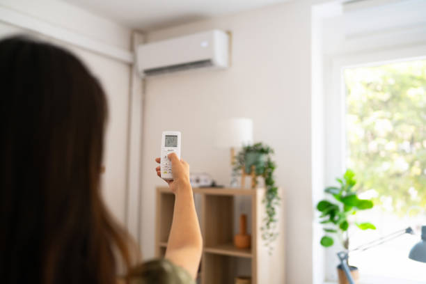 istock Woman turning on air conditioner with remote control 1542270540