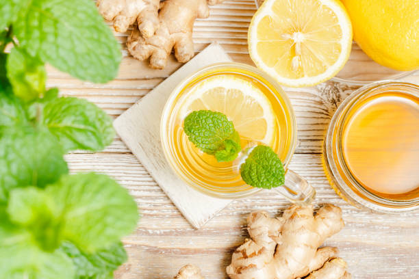 istock Healthy tea with ginger, lemon, honey and mint leaf, top view, wooden background 1542276881