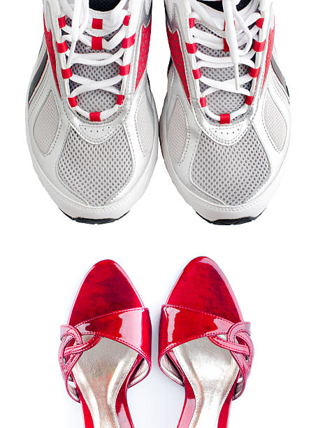 Cropped shot of a woman in running shoes holding her high heels