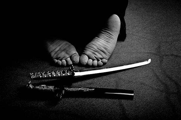 Man`s feet and ritual sword Man`s feet and ritual sword in black and white harakiri photos stock pictures, royalty-free photos & images