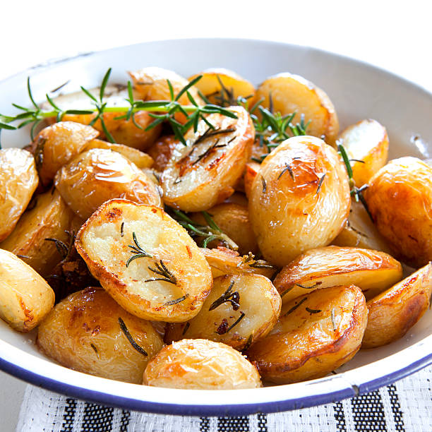 patatas asadas con romero - roasted potatoes prepared potato herb food fotografías e imágenes de stock