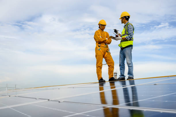 istock Specialist technicians engineer explain to the Installation worker head to check quality of installing solar photovoltaic panels and current capacity on rooftop with technology apps on tablet. 1542333409