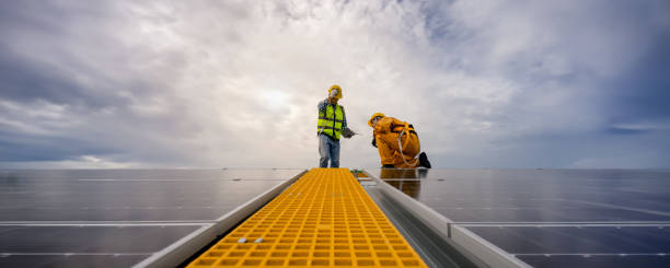 istock Specialist technicians engineer and Installation worker head to check quality of installing solar photovoltaic panels with technology tablet on center gable rooftop. Banner size with copy space. 1542333411