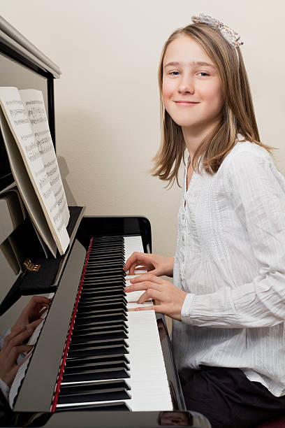 istock Happy young girl playing the piano 154234623