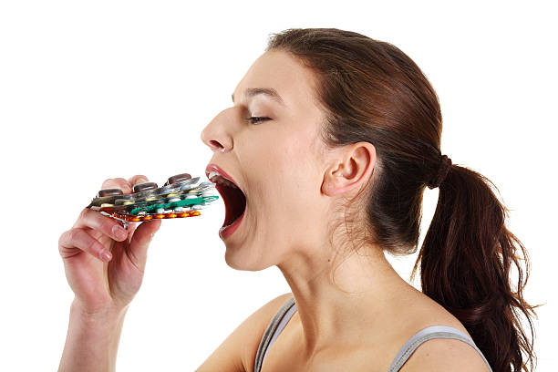 женщина ест таблетки - vitamin pill picking up pill capsule стоковые фото и изображения