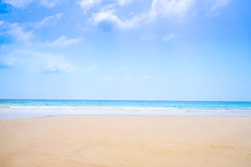 Beach sand background for summer vacation concept. Beach nature and summer seawater with sunlight light sandy beach Sparkling sea water contrast with the blue sky.