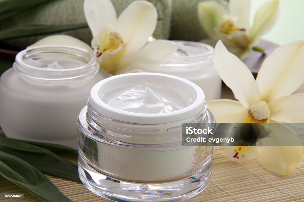 Orchid and Face Cream White Cymbidium orchid flower and jar of moisturizing face cream for spa treatment. Beauty Product Stock Photo