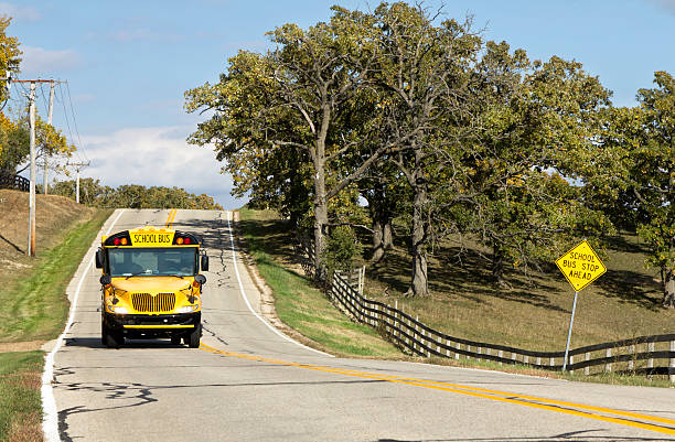 American country asphalt road with school bus sign stock photo