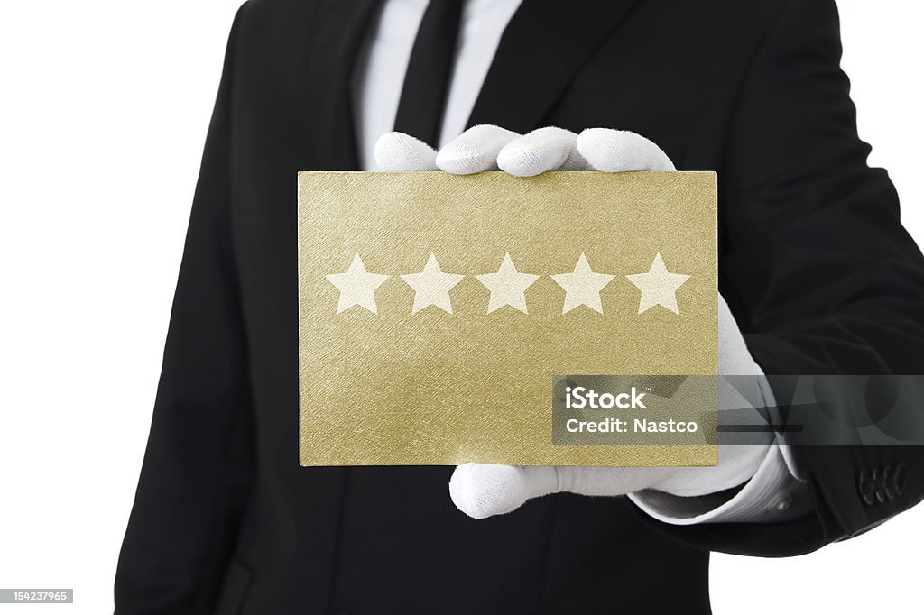 Top class service Human hand holding gold card with five stars on it Glove Stock Photo