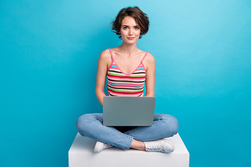 Full body portrait of nice positive lady sit podium use wireless netbook coworking isolated on blue color background.