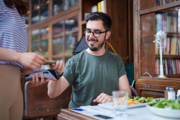 istock The man paying the restaurant bill with his mobile phone 1542397393