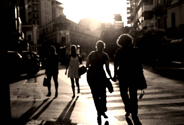 traverser la rue - shadow focus on shadow women sunset photos et images de collection