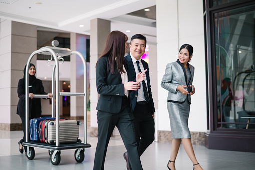 Group of business people walking in a hotel corridor.
