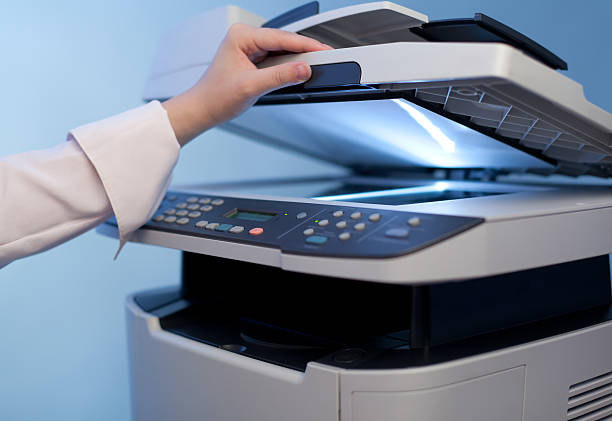 A woman's hand on the scanner part of a printer stock photo