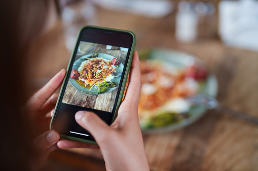 Taking a top-down photo of the meal with their phone