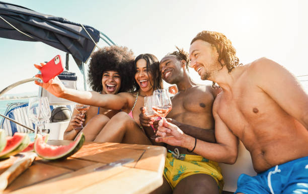 istock Happy multiracial friends taking selfie while drinking champagne on sail boat - Summer vacation, party and travel concept - Focus on center people faces 1542459202