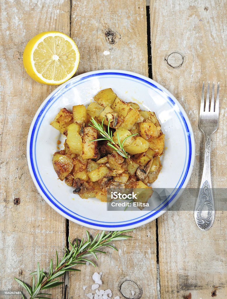 Dish from country style roasted potatoes Roasted potatoes and rosemary country style on wooden background Baked Stock Photo