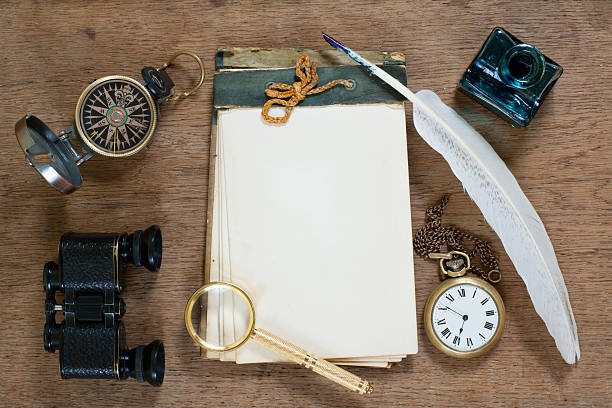 istock Old notebook, compass, binoculars, watch, quill, magnifying glass on wood 154247491
