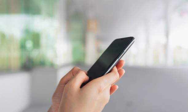 istock Hand using smartphone in public areas, During leisure time. The concept of using the phone is essential in everyday life. 1542479579