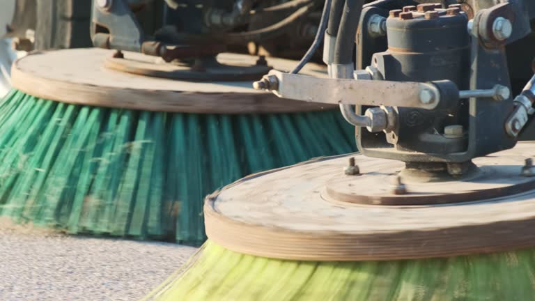 Rotating brushes of cleaning machine clean debris on bridge