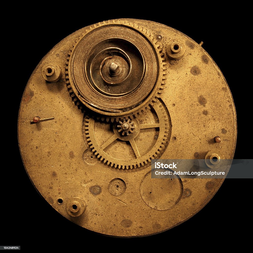 Circular brass watch clock part with spring and gear An old brass circle shape watch part made of brass with a coiled spring and gear. Ancient Stock Photo