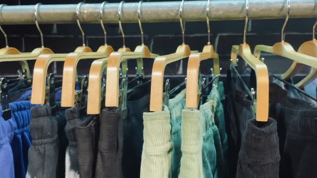 Pants on a hanger in a clothing store, slow motion close-up video