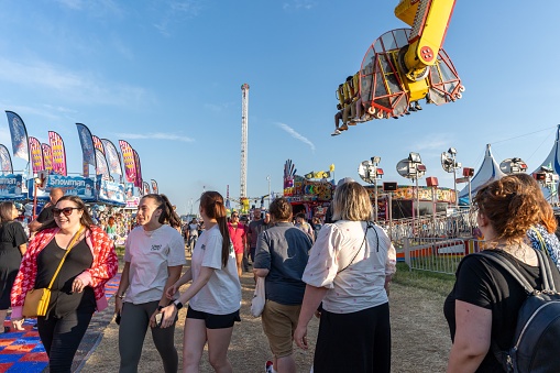 Newcastle upon Tyne, United Kingdom – June 21, 2023: People having fun at the fair, as the Hoppings fairground or showground visits the city of Newcastle upon Tyne, UK