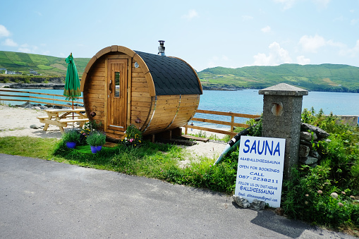 Allihies, Ireland - June 20th, 2023: Exterior view of a mobile wooden sauna overlooking the beach at Allihies, County Cork, Ireland. Allihies is on the popular tourist route named the Wild Atlantic Way on the west coast.