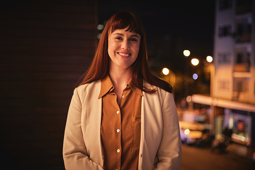 Night, smile and portrait of business woman in city for professional, corporate and overtime. Happy, mindset and pride with employee in outdoors for manager, company and mission with mockup space