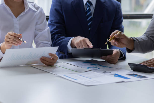 istock Team of Business people working at workplace with tablet and document, doing planning analyzing Tax financial report, business plan investment, finance analysis Economic business discussions. 1542565631