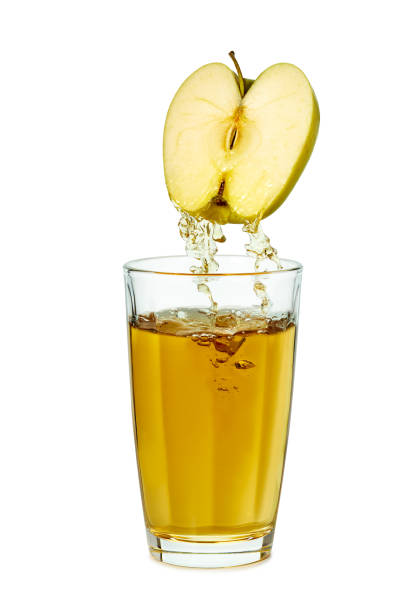 istock Juice poring from apple half to glass on white background 1542575009