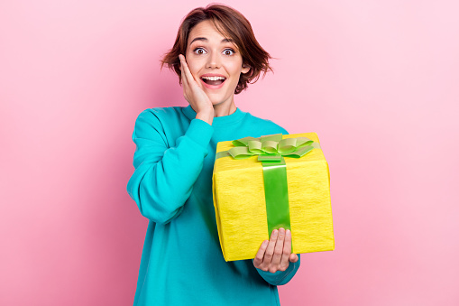 Portrait of cheerful positive glad lady wear stylish clothes hold birthday gift box isolated on pink color background.