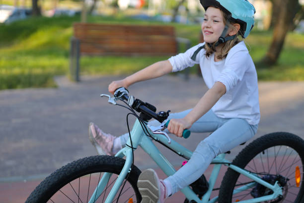 istock Cheerful leisure on a bicycle, a girl in a helmet has fun. 1542623846