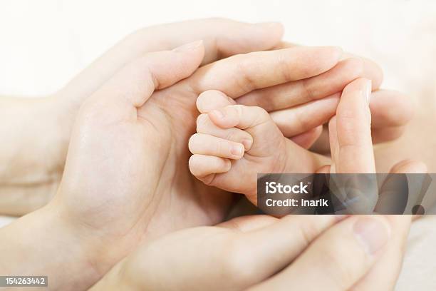 Bebé De La Mano En Manos De Los Padres Concepto De Familia Foto de stock y más banco de imágenes de Abrazar