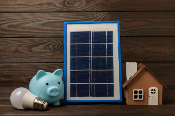 istock Flat lay composition with solar panel, led lamp and piggy bank on  background. The concept of saving money and clean energy. The concept of ecology and sustainable development. 1542643536