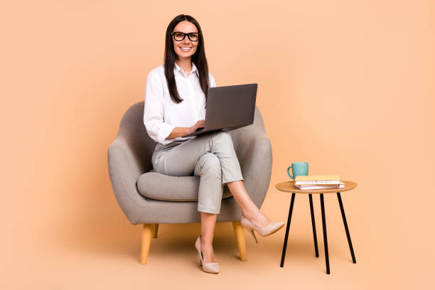 istock Full size photo of cheerful data analytic worker young lady sit chair with netbook remote communicating isolated on beige color background 1542645008