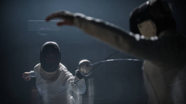istock Two professional fencers foil swords facing each other in combat ready poses 1542653087