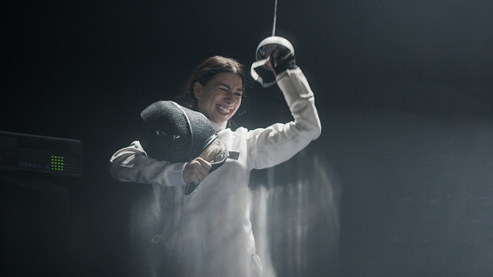 Fencer winning a professional fencing championship. Cheering in joy