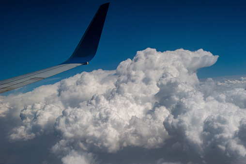 The wing tip of the butler passing by the dense cloud clusters