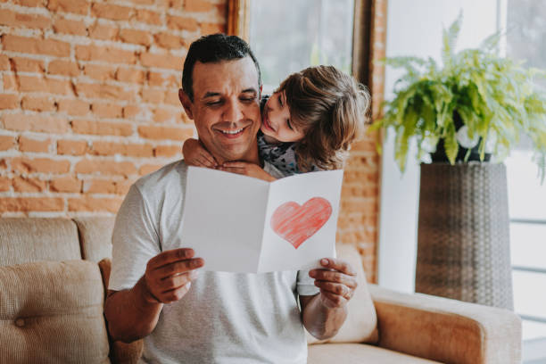 istock Son handing postcard to father on father's day 1542664440