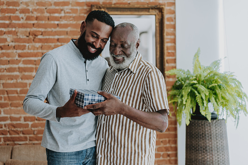 Adult son giving gift to senior father