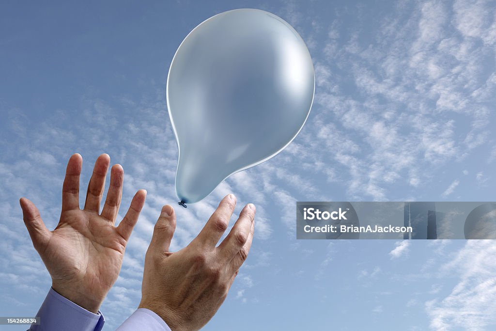 Aspirations concept with hands and balloon Releasing a balloon into the air concept for dreams and aspirations with copy space on the balloon and sky Balloon Stock Photo