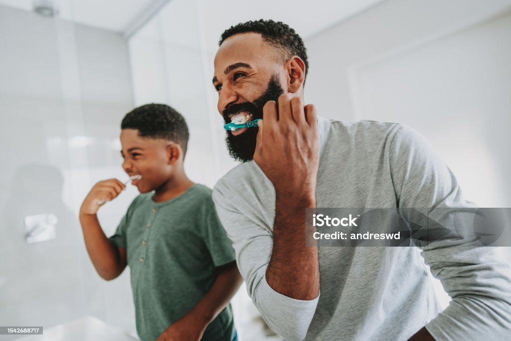 Father teaching son to brush teeth Dental Health Stock Photo